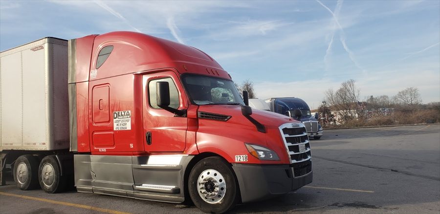Delta Carrier Group red Freightliner Cascadia (new gen) unit 1218 parking