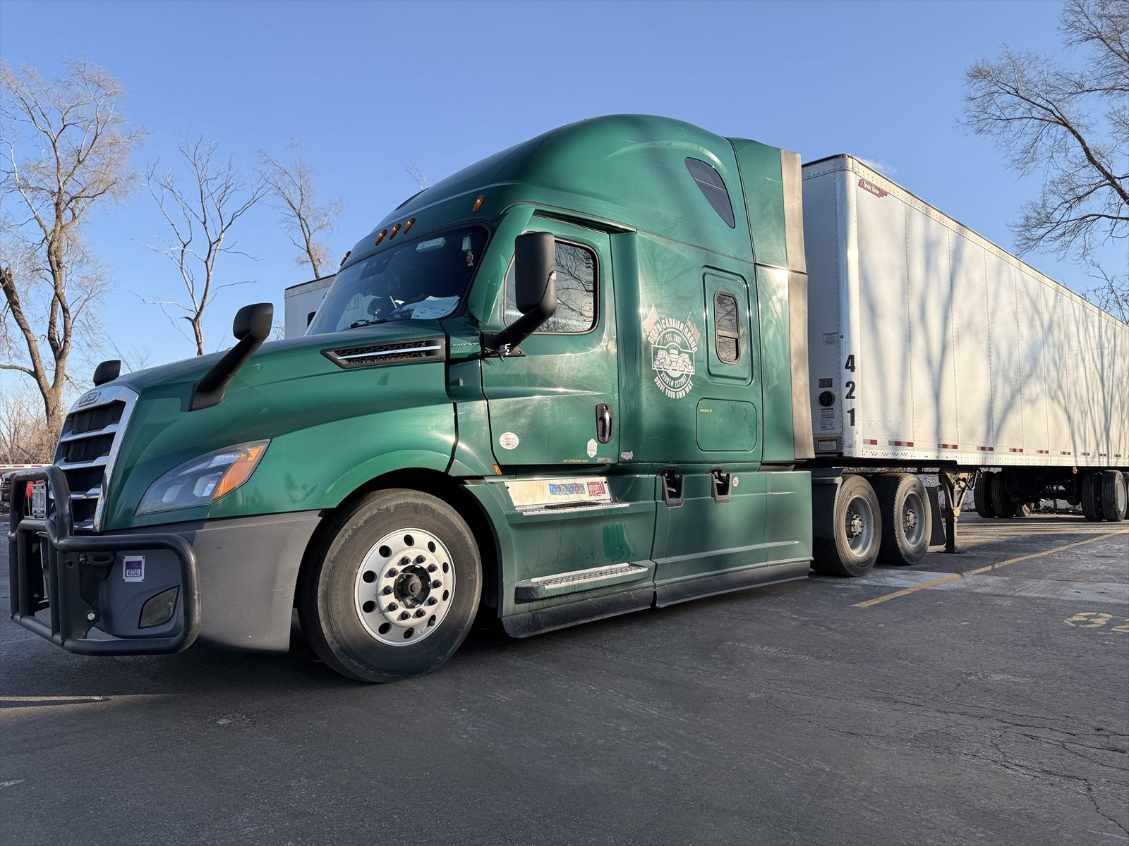 Delta Carrier Group tractor coupled to a 53-foot dry van trailer in golden-hour light